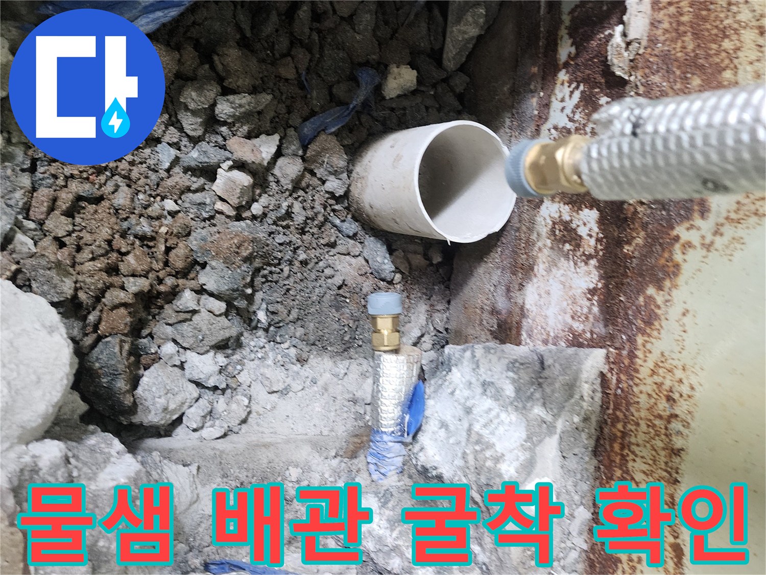 파헤쳐진 바닥 속 노출된 은색 및 파란색 배관 라인
