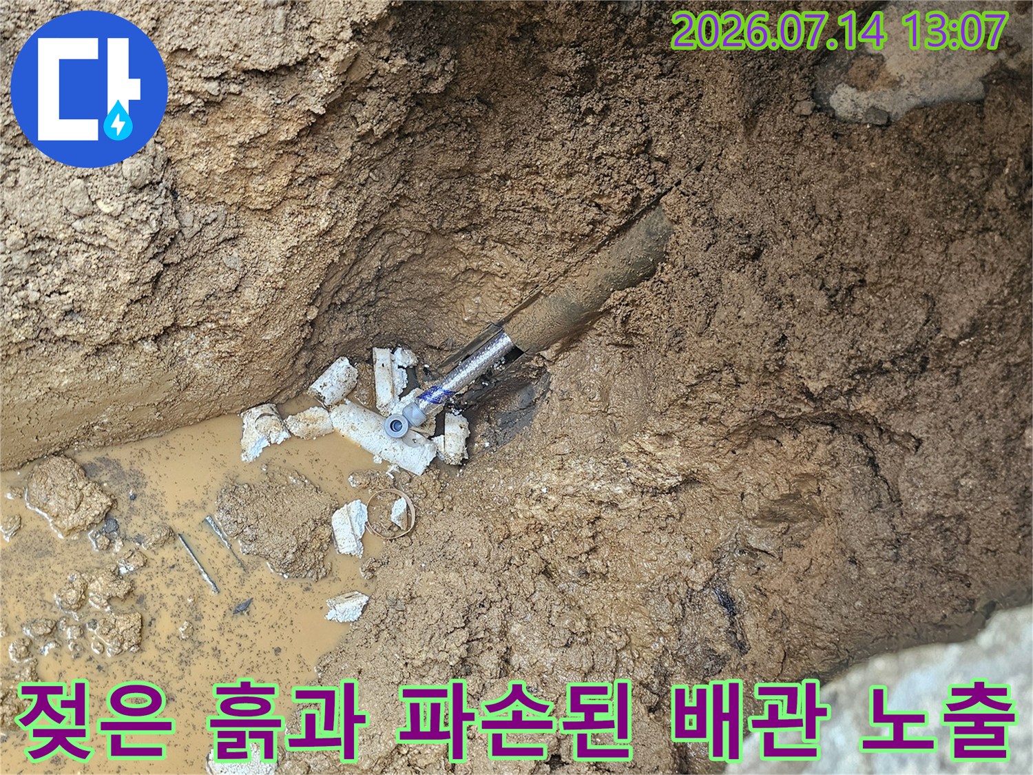 물에 젖어 있는 토양 속에 드러난 손상된 수도관
