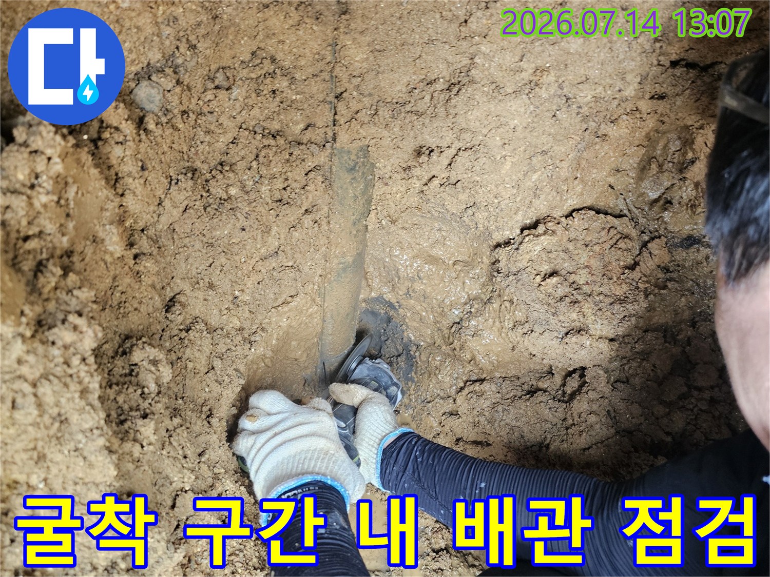 흙을 파내어 드러난 누수 지점을 직접 손으로 확인하며 점검하는 작업 현장