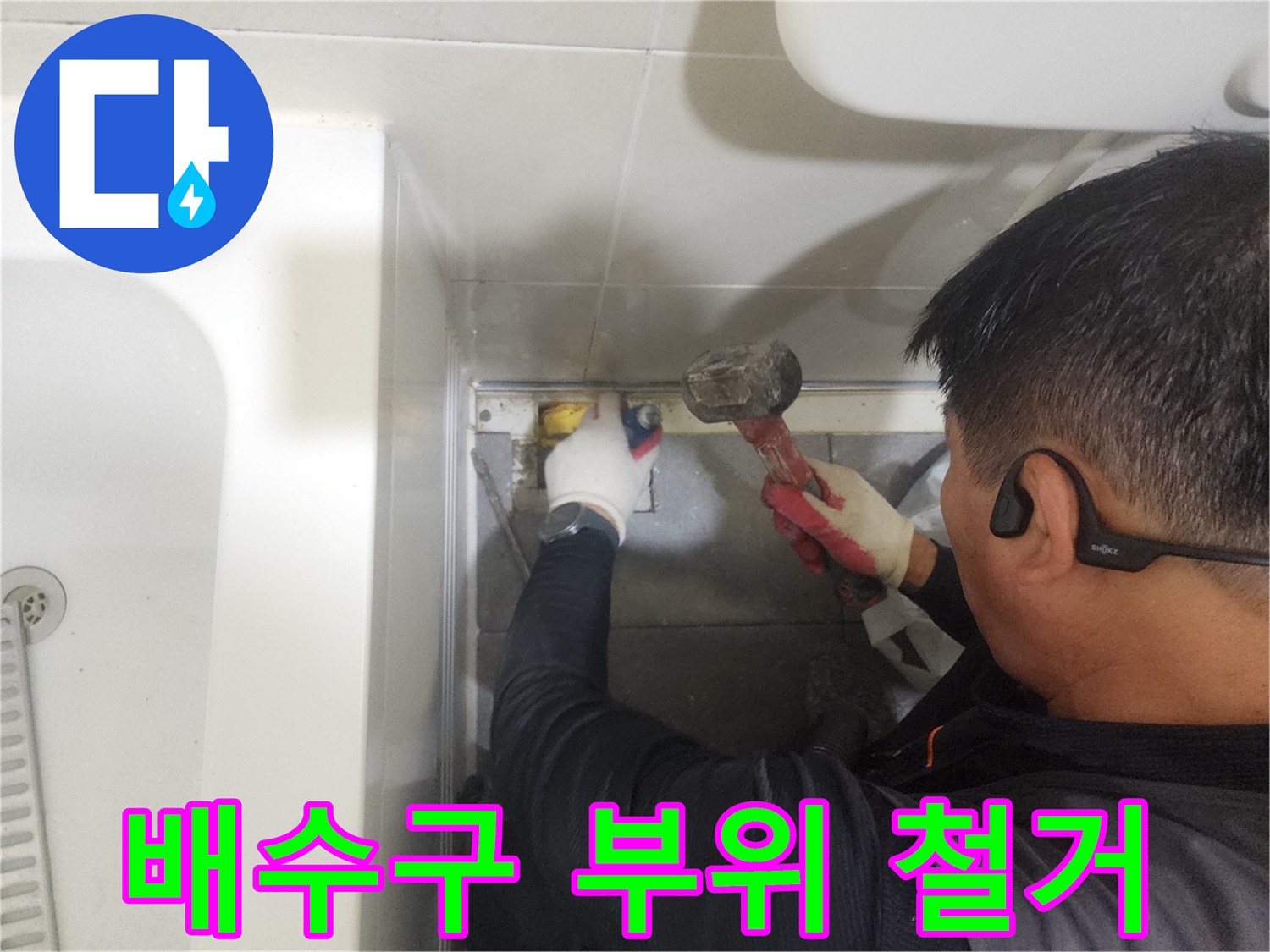 분당 현장에서-망치를 사용해 배수구 주변의 노후된 마감재를 제거하는 중입니다.