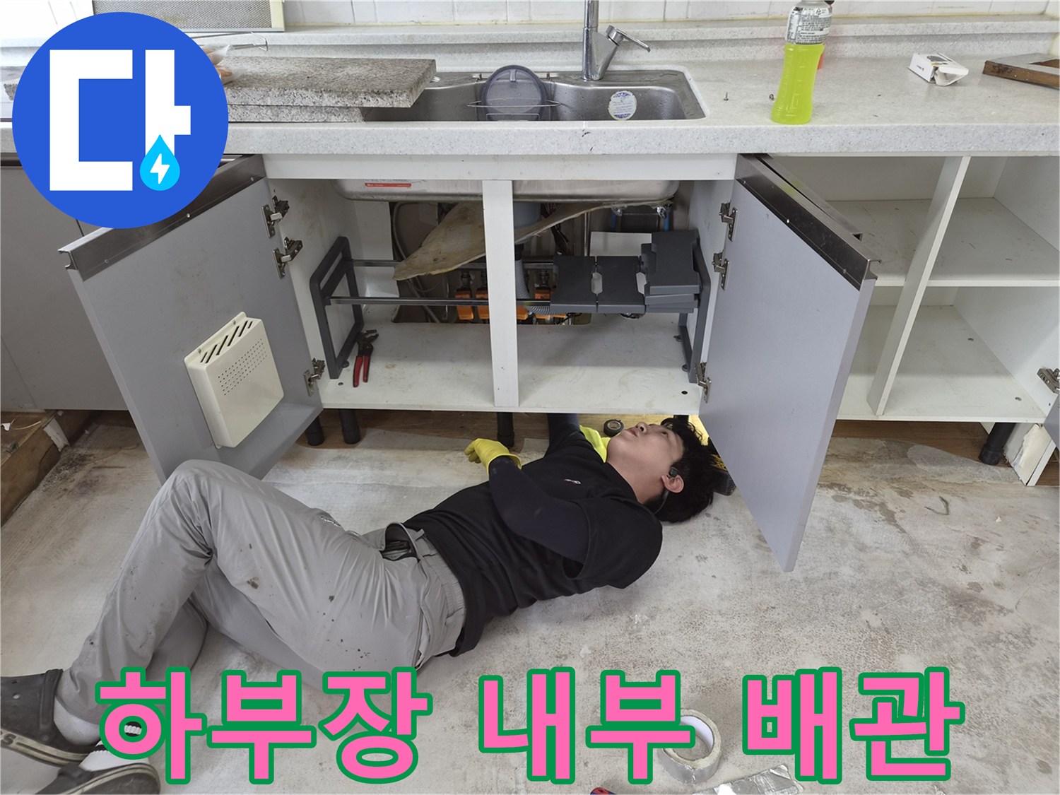 싱크대 하부장 안쪽의 배관 부위를 조사하는 모습