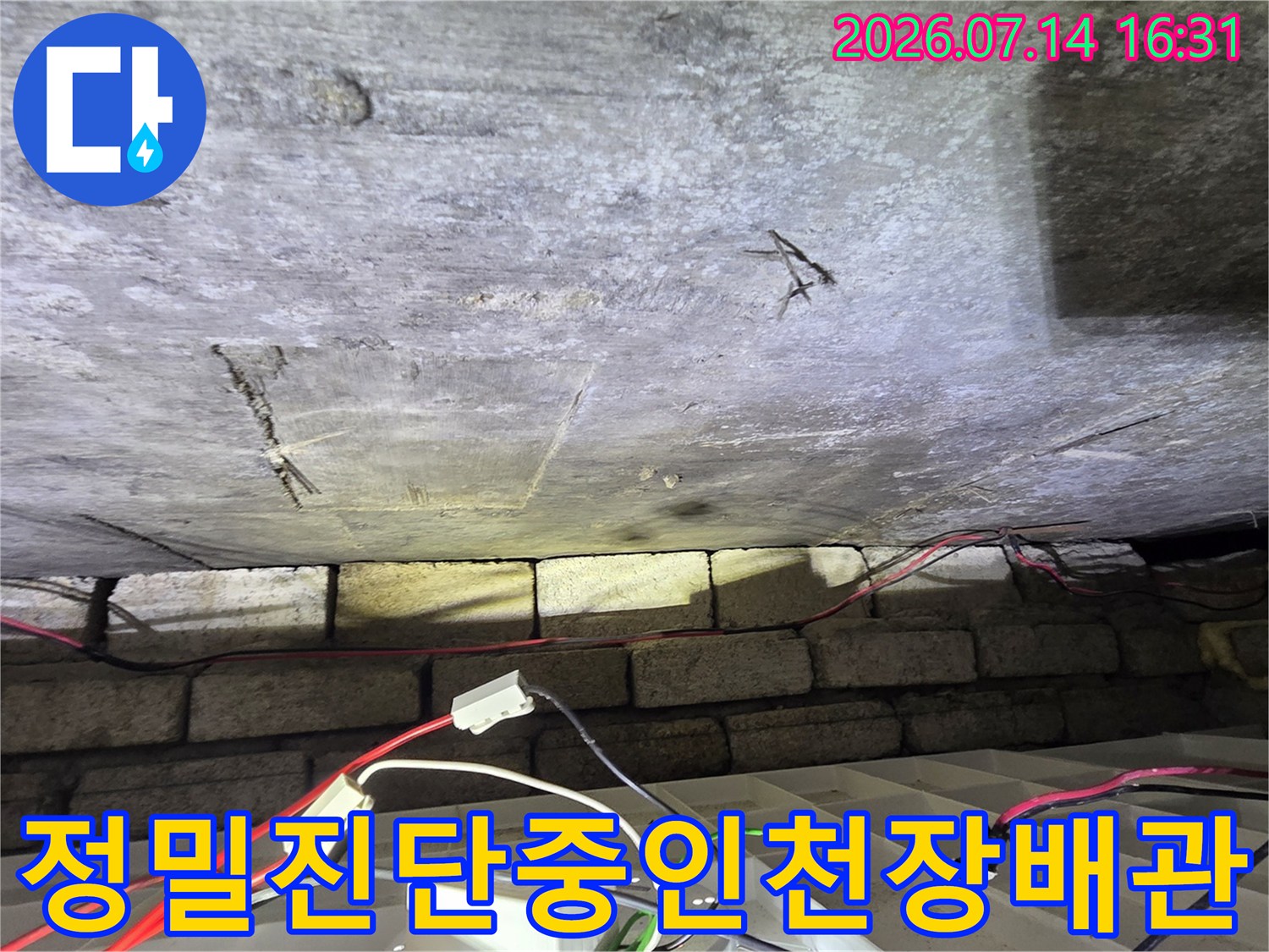노출된 천장 배관에 기구 및 장비를 연결하여 누수 여부를 진단하는 장면