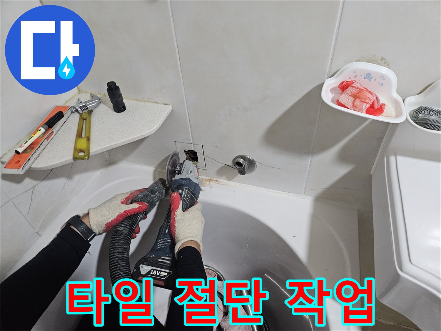 배관 수리를 위해 벽면 타일을 정밀하게 잘라내는 공구 사용 모습