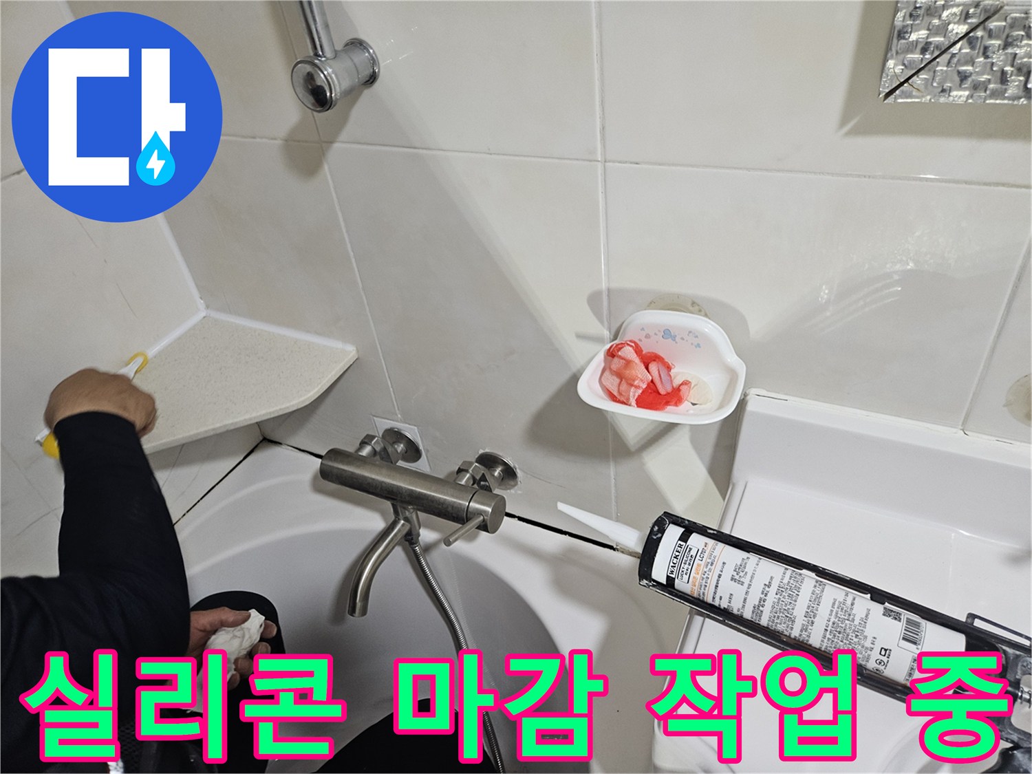 백색 실리콘을 사용하여 욕조 테두리 틈새를 메우는 장면입니다.
