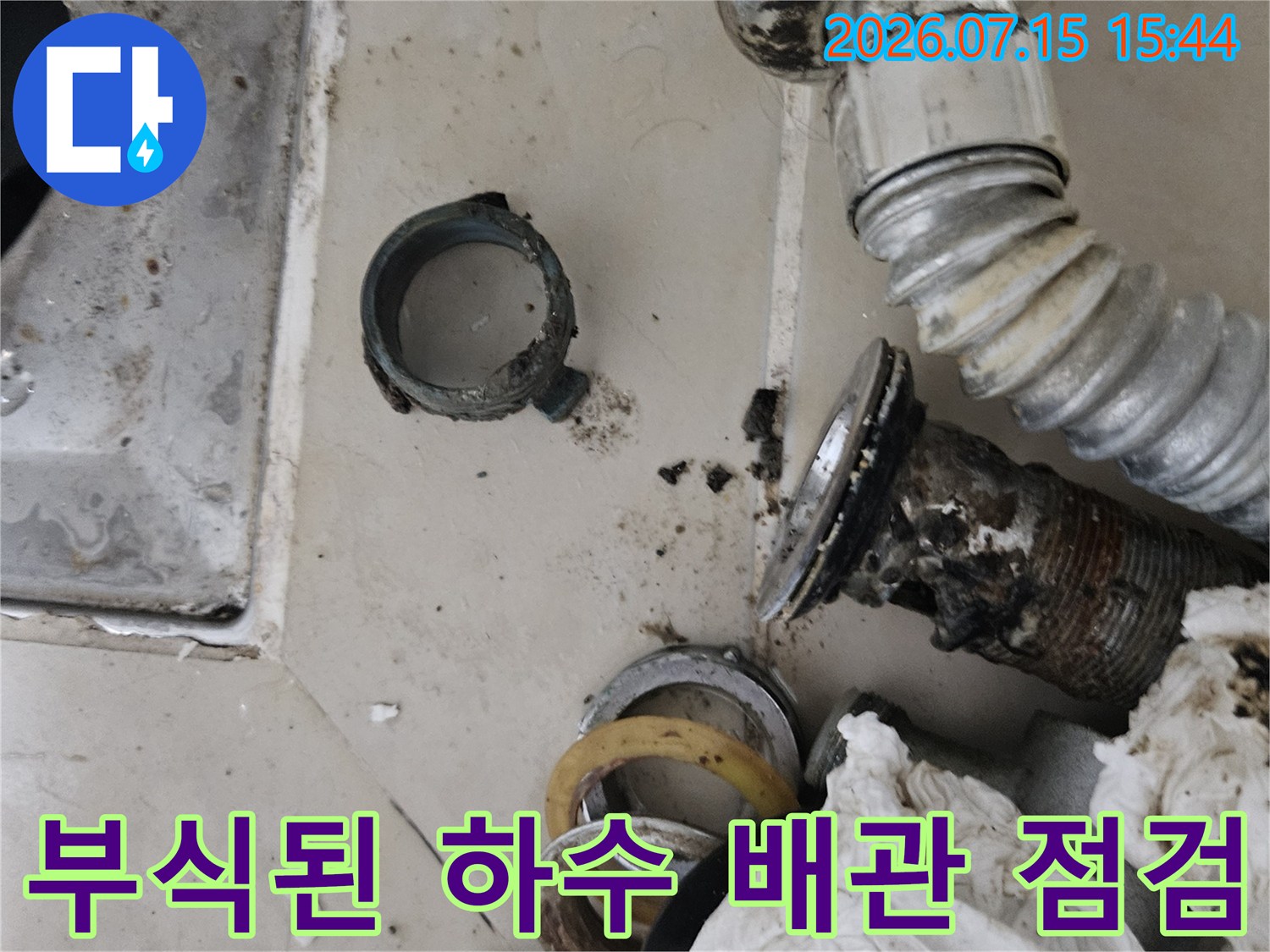 세면대 밑에 위치한 노후된 금속 재질의 배출 파이프와 연결 상태를 촬영했습니다.