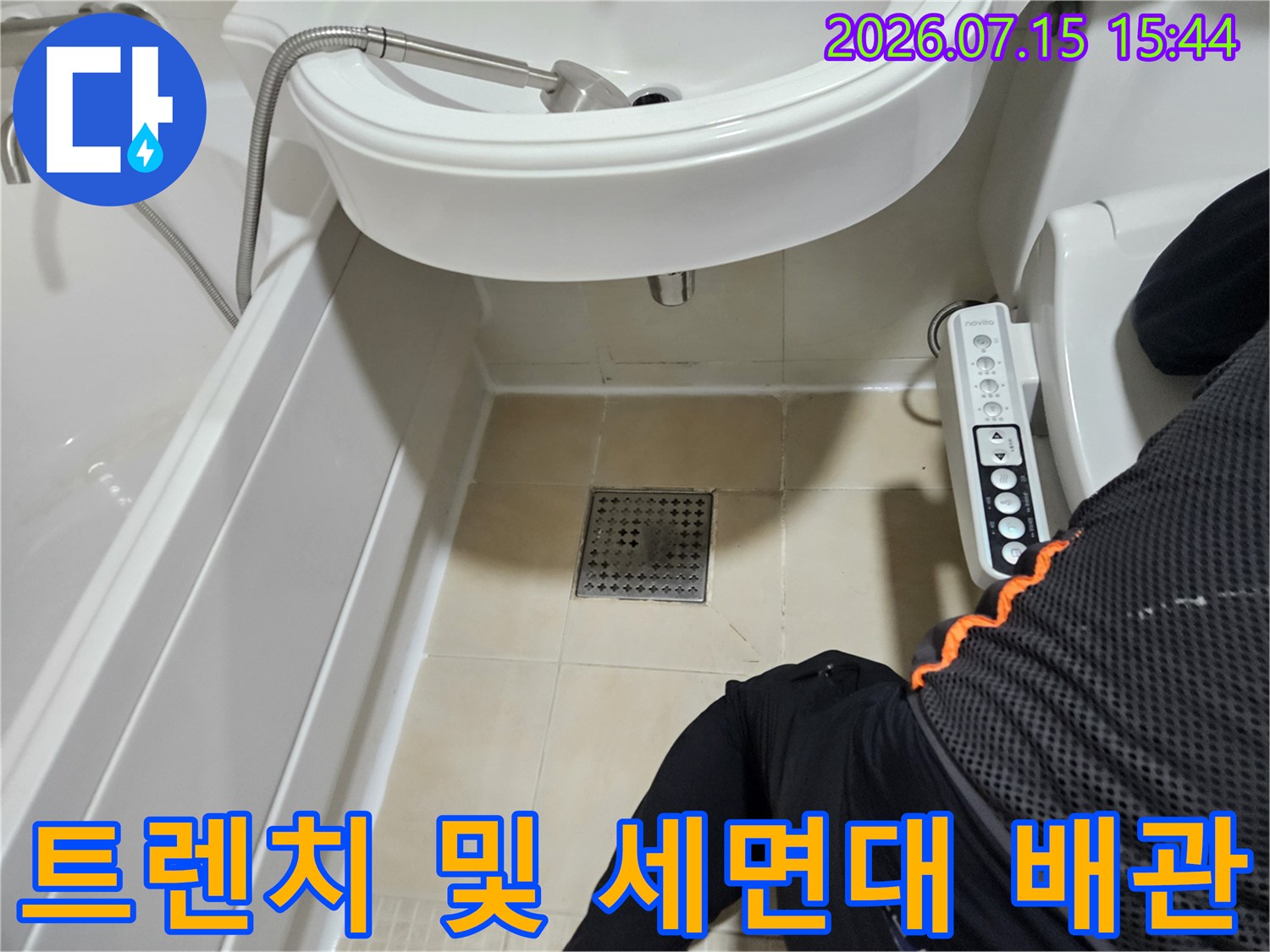 세면대 아래 트렌치와 배관 연결 부위를 꼼꼼하게 점검하는 모습