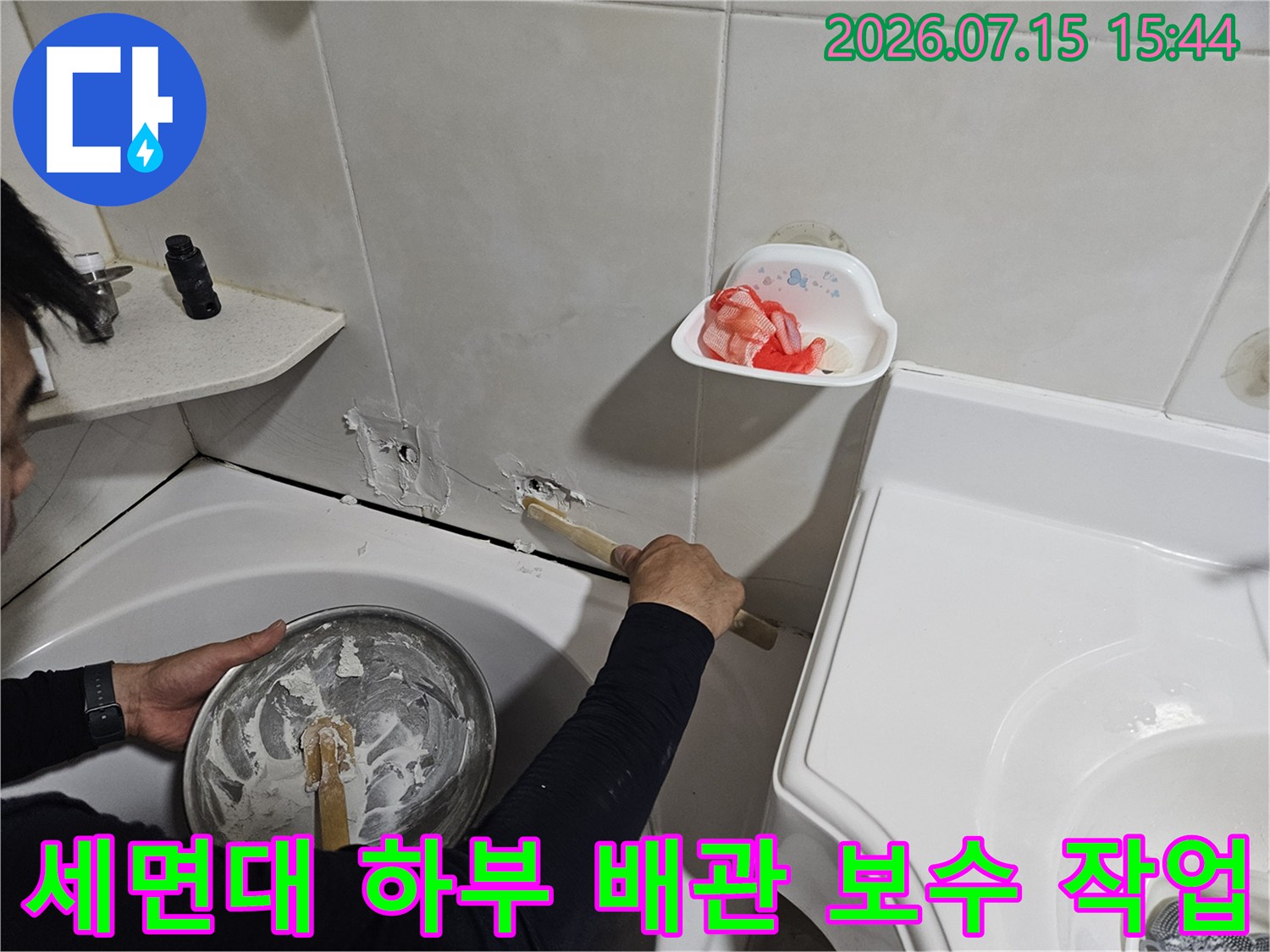 세면대 아래쪽 노출된 배관을 점검하며 수리 작업을 진행하는 모습