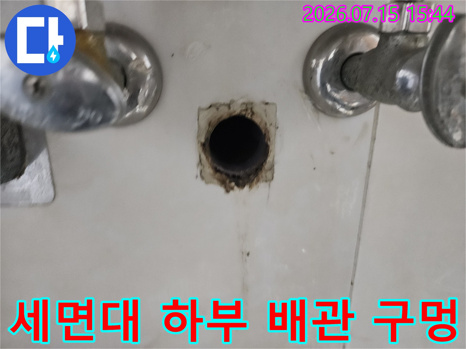 세면대 아래쪽 배관 연결 부위의 마감재를 제거한 모습