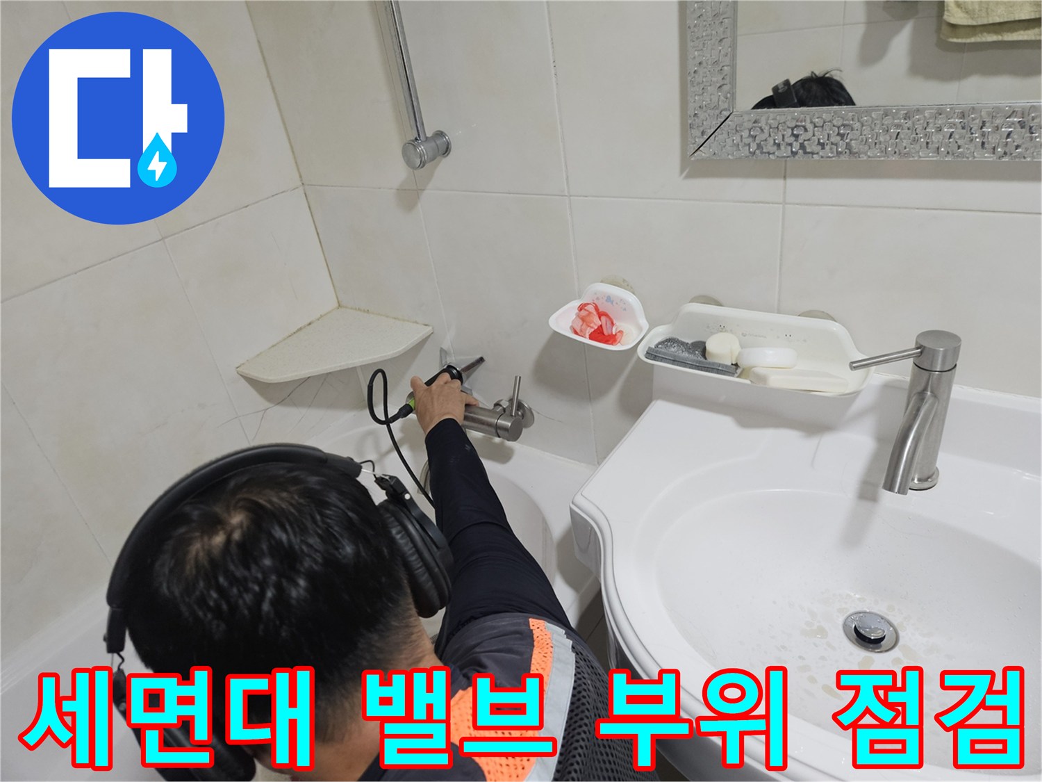 세면대 아래쪽 수도 연결 부위를 엔지니어가 점검하고 있습니다.