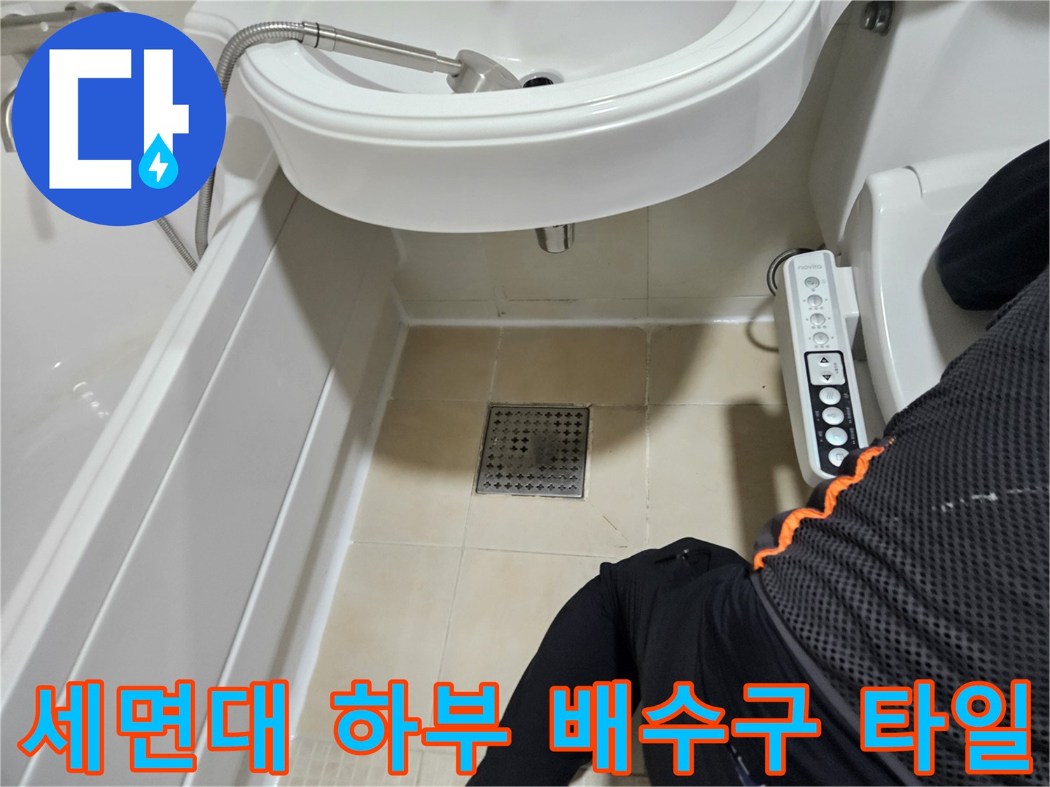 세면대 아래쪽 욕실 바닥 타일과 배수구 덮개 사진입니다.