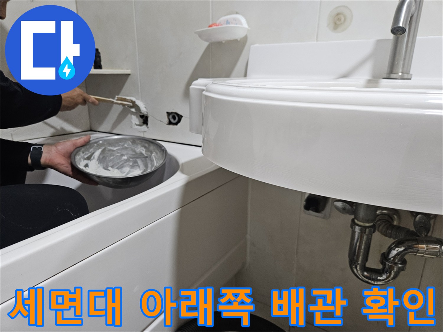 세면대 하단 연결 부위의 상태를 살피고 있는 작업 사진