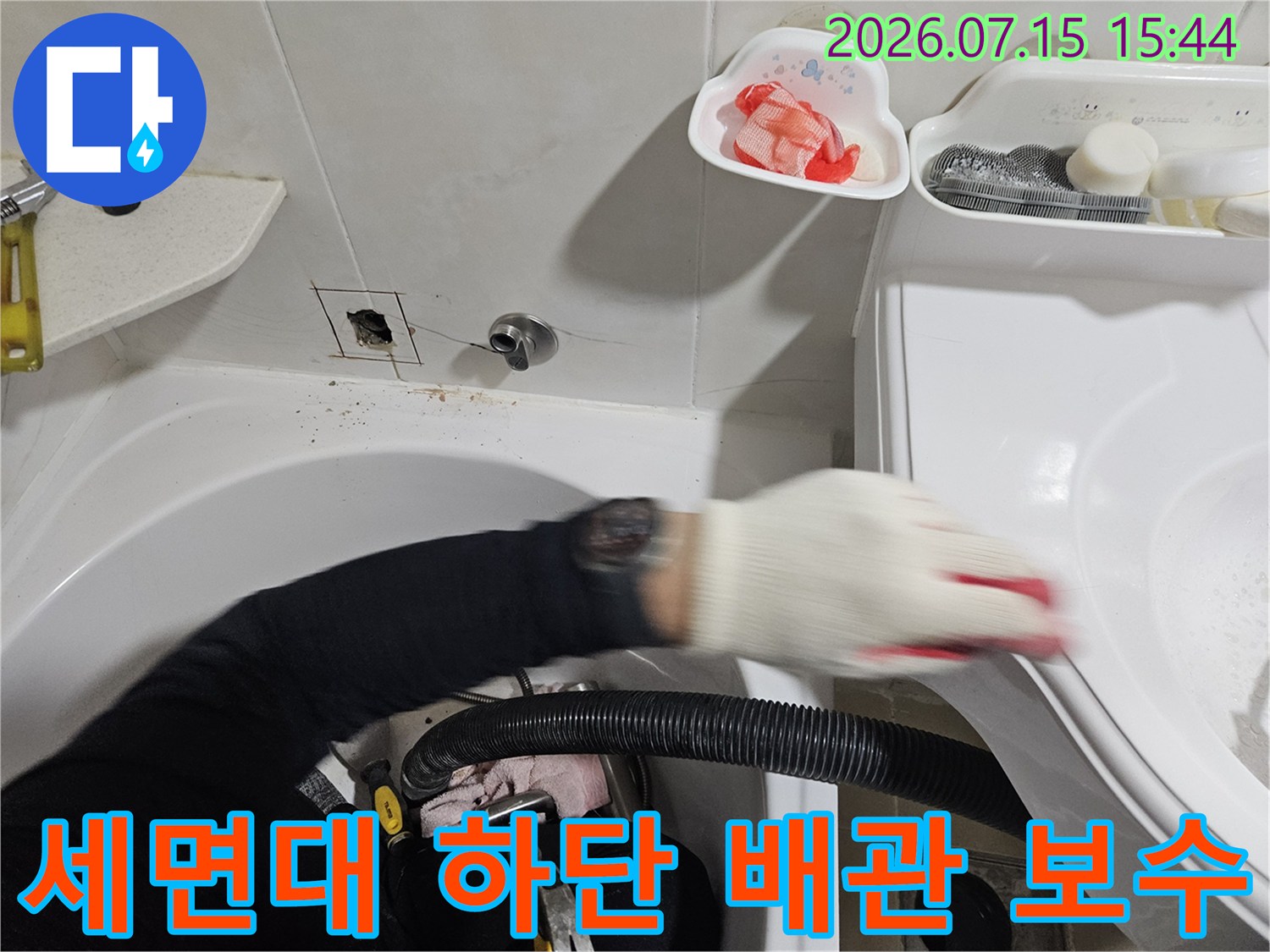 전문가가 세면대 밑의 누수가 발생한 배관을 정밀 점검하는 모습입니다.