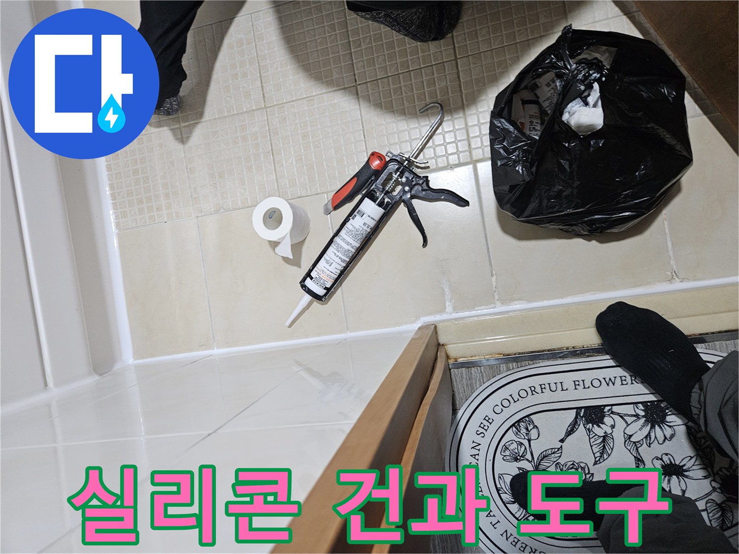 타일 바닥에 놓인 실리콘 건과 작업용 소모품들