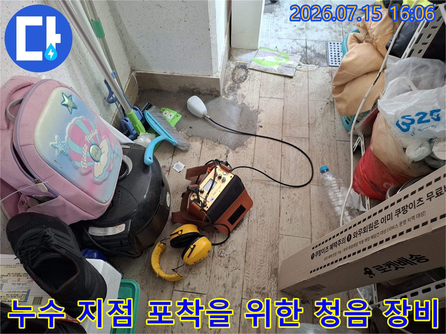 타일 바닥에 세팅된 누수 정밀 탐지기-노란색 헤드셋과 센서 연결선