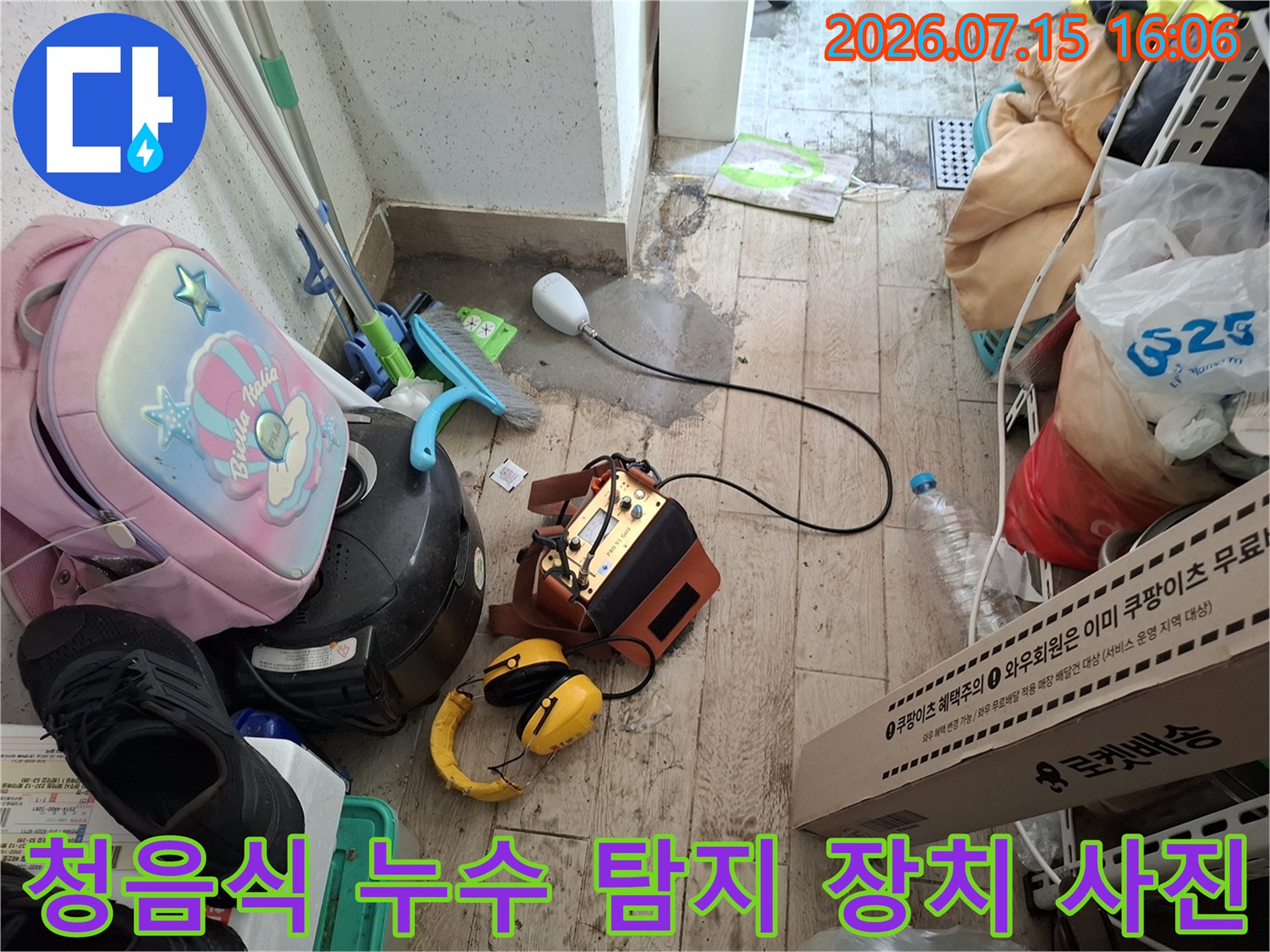현장 바닥에 배치된-누수탐지 본체와 헤드셋 및 측정용 센서