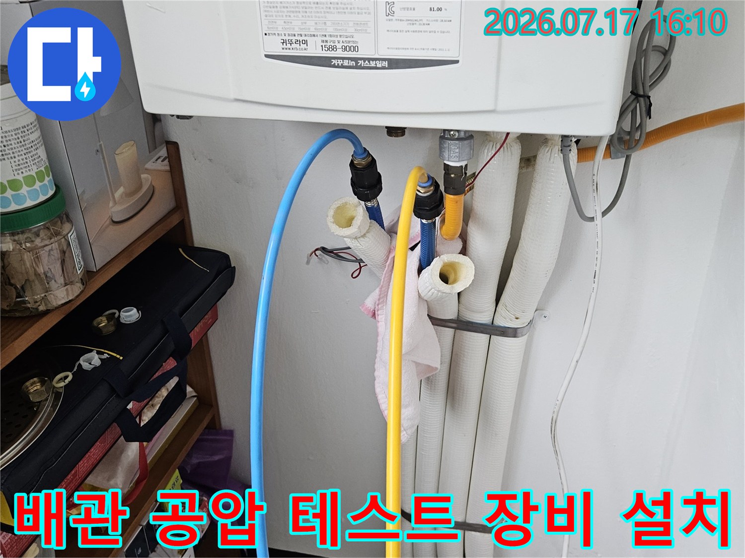 노란색과 파란색 호스로 연결된 배관에 압력 측정 게이지를 설치하여 누수 여부를 점검하는 모습