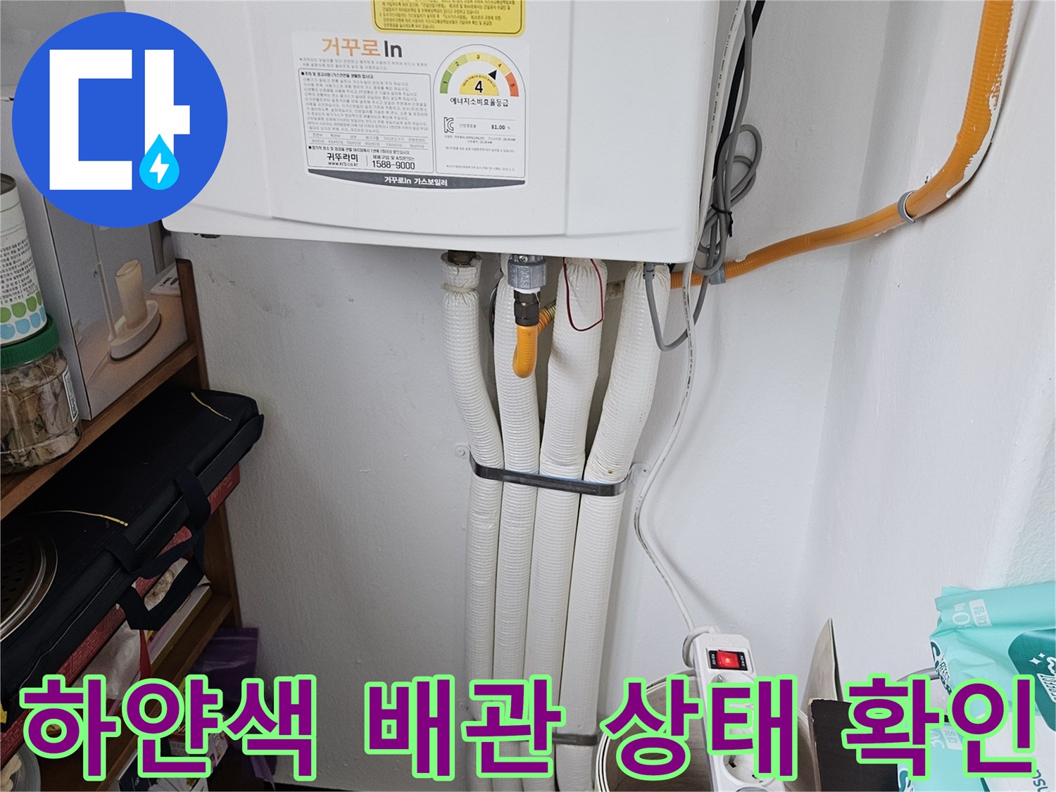 세탁실 내부의 하얀색 배관과 노란색 호스 연결부
