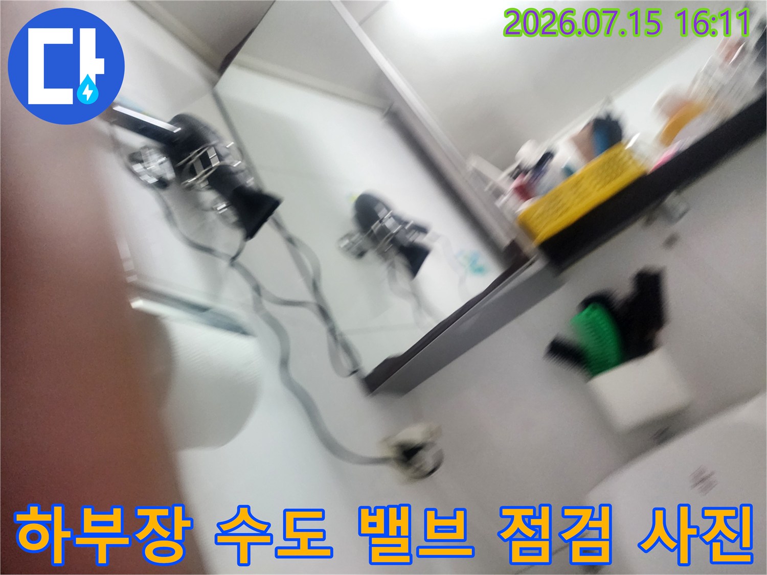 싱크대 내부의 금속제 수도 밸브-및 흰색 전기 전선이 배치된 상태