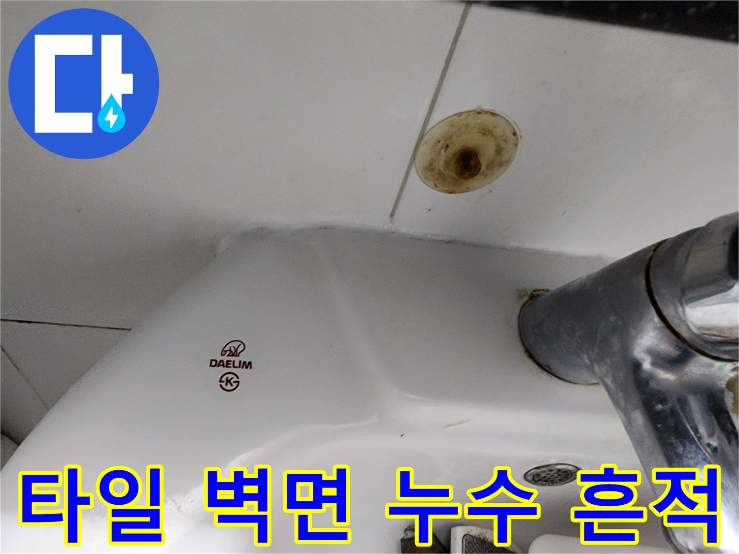 세면대 뒤쪽 타일의 갈색 누수 오염 부위
