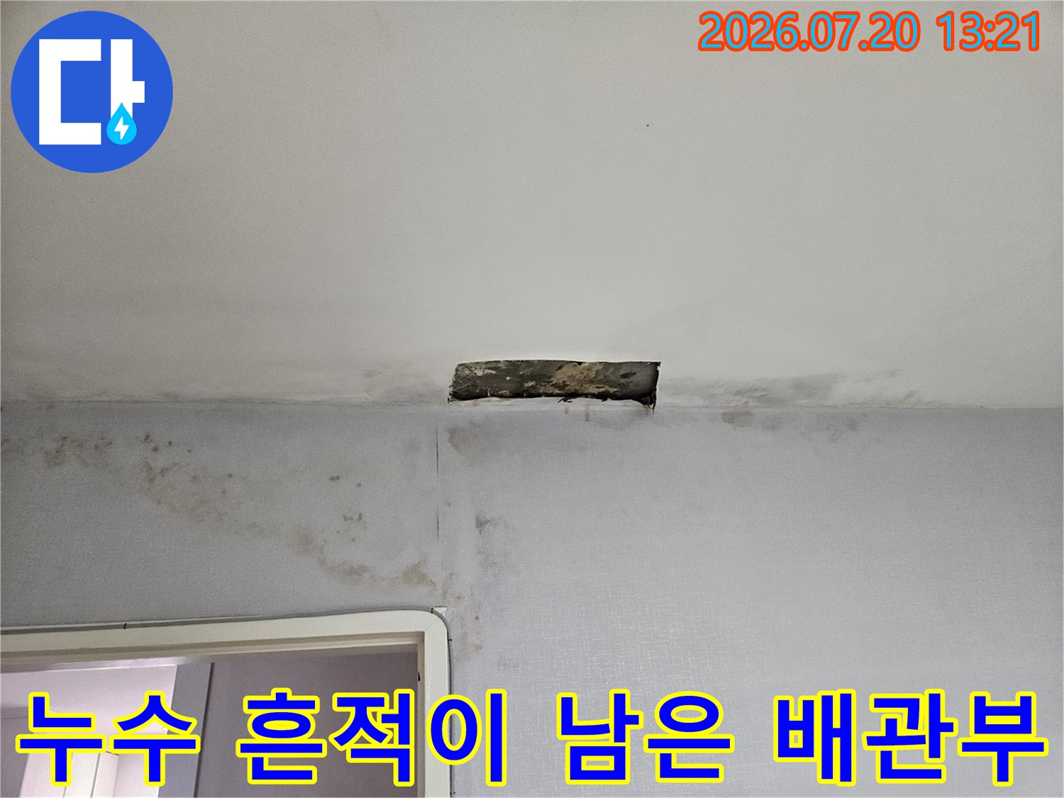 오염된 천장 마감재와 노출 배관 부위의 근접 촬영