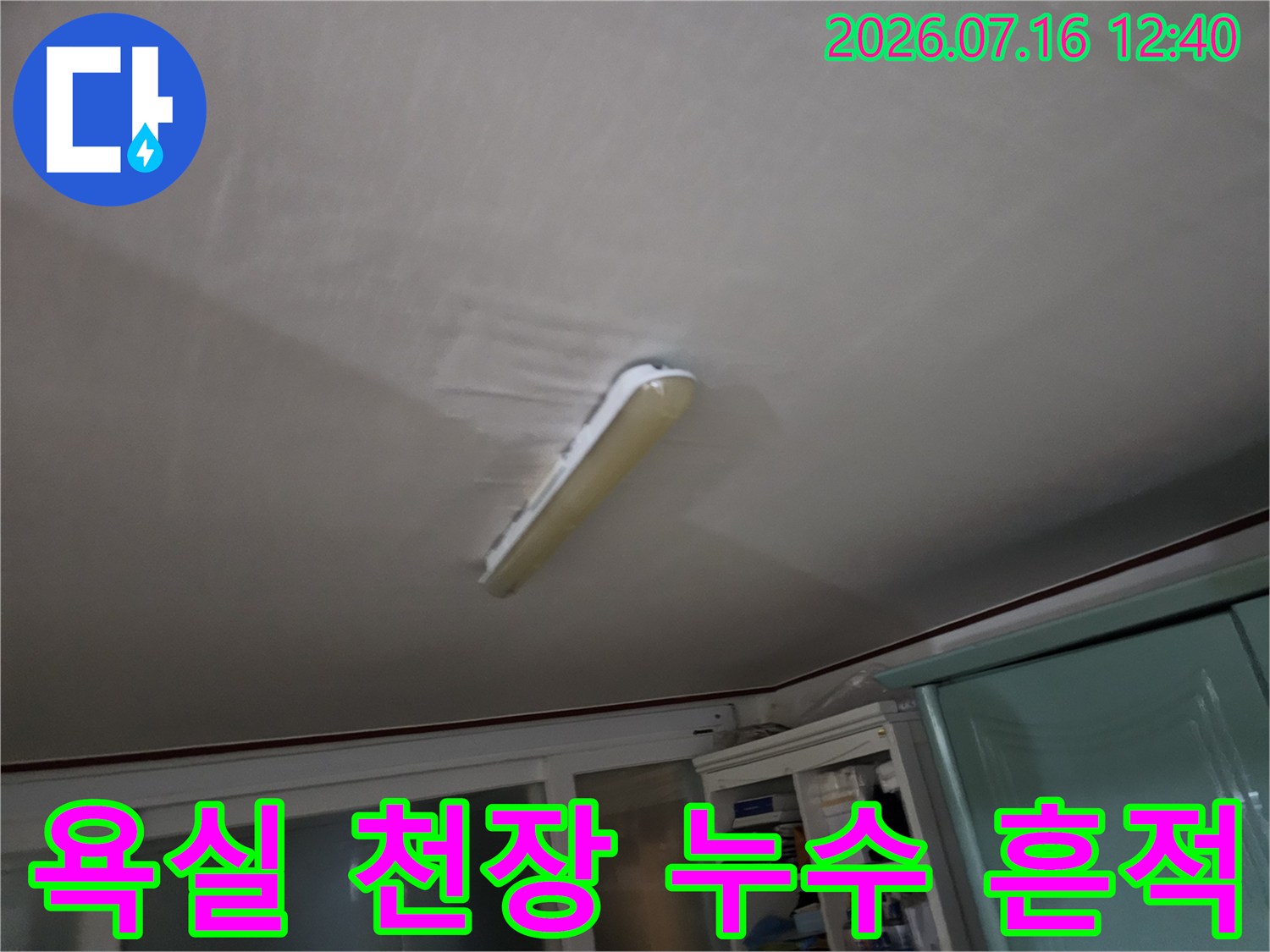 화장실 천장 안쪽에 설치된 조명 기구와 습기로 인한 오염 상태