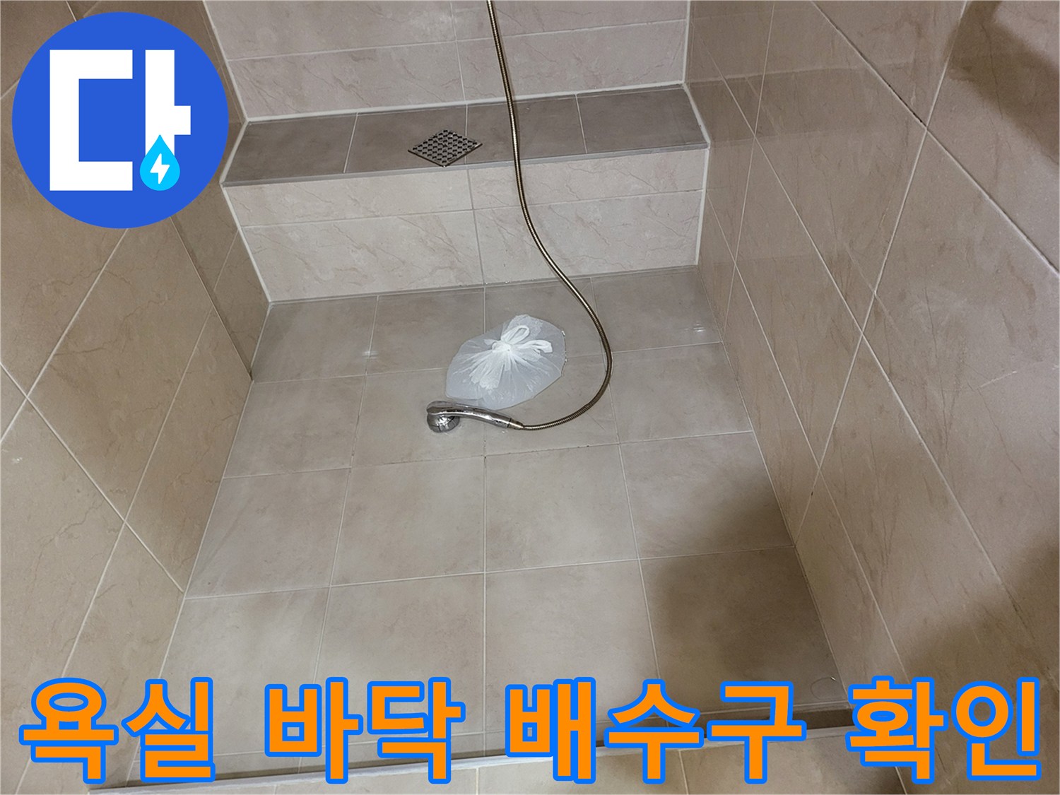 샤워기 수전과 바닥 배수구가 있는 욕실 내부 모습입니다.