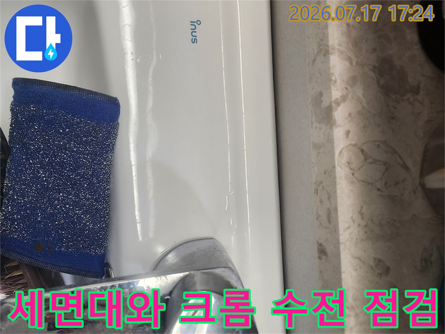 흰색 세면대에 설치된 금속 소재의 수도꼭지 확인