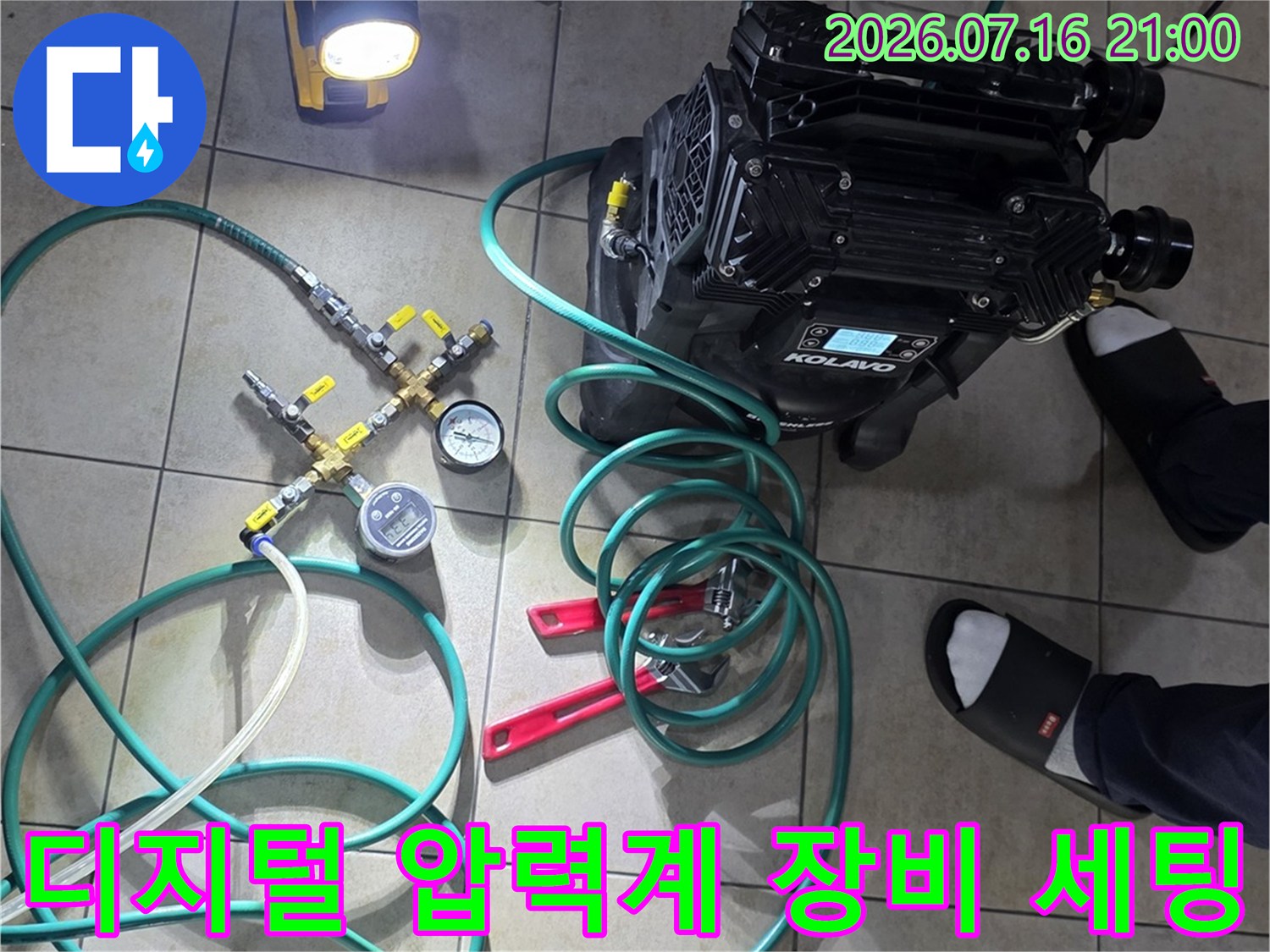 초록색 호스와 디지털 압력계를 활용한 배관 기밀성 테스트 장면