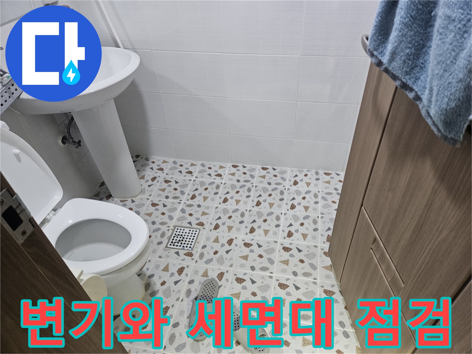 화장실 변기 하단과 옆에 위치한 세면대 모습