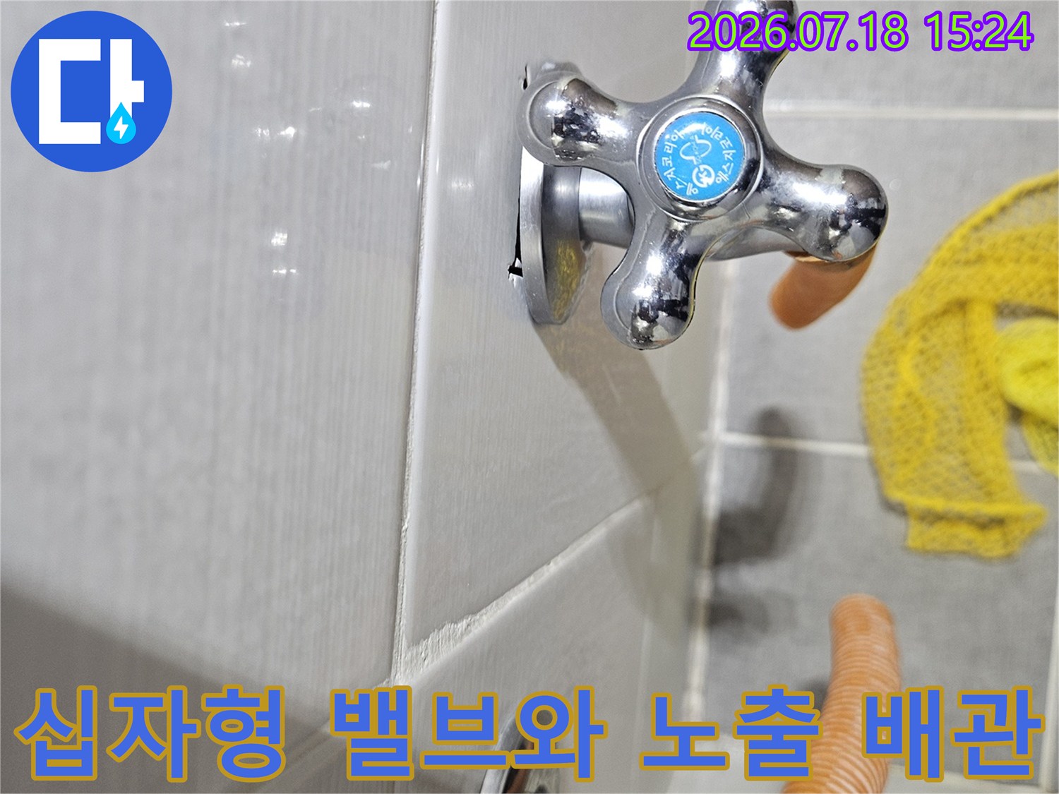 흰색 타일 바닥에 설치된 크롬 소재의 수전 밸브