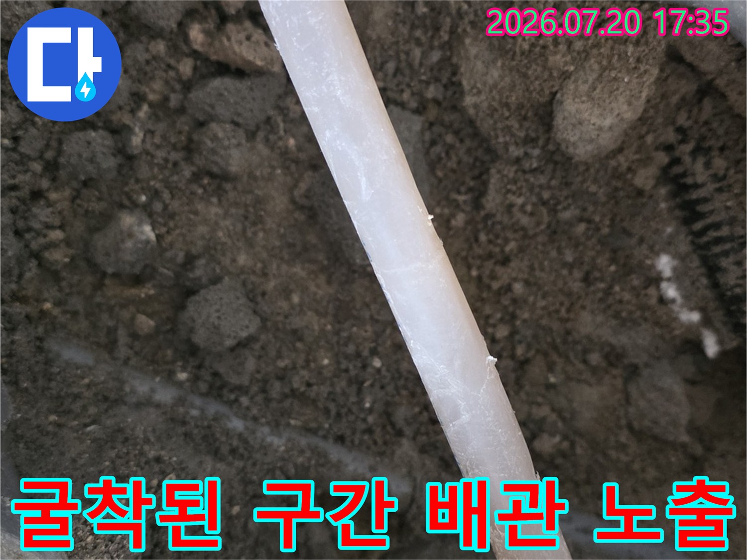 흙바닥 속에서 발견된 회색 배관의 파손 부위 점검