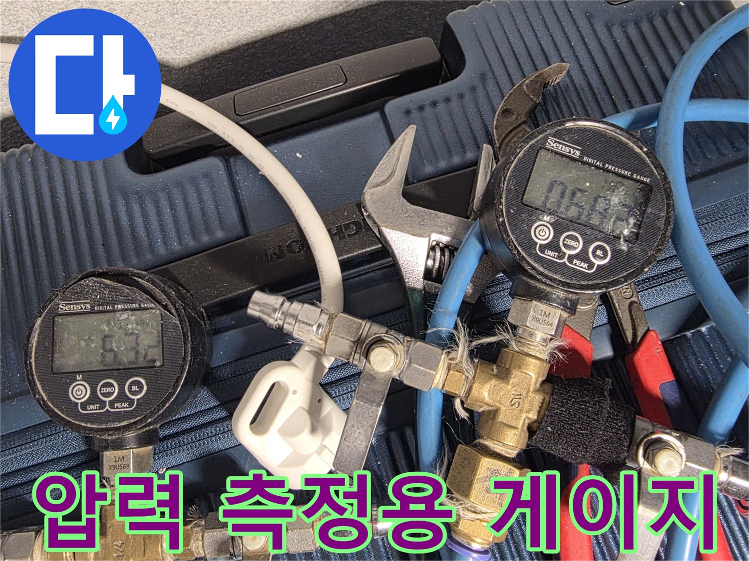 배관에 연결된 디지털 압력계와 파란색 및 빨간색 호스들