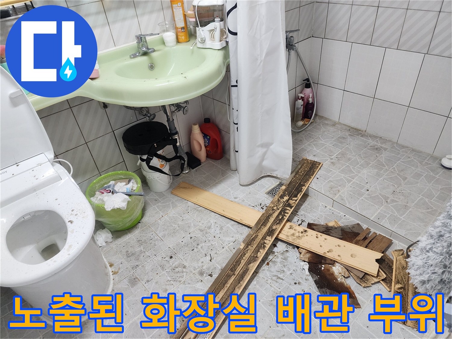 세면대 하부 배관과 파손된 바닥 마감재의 모습