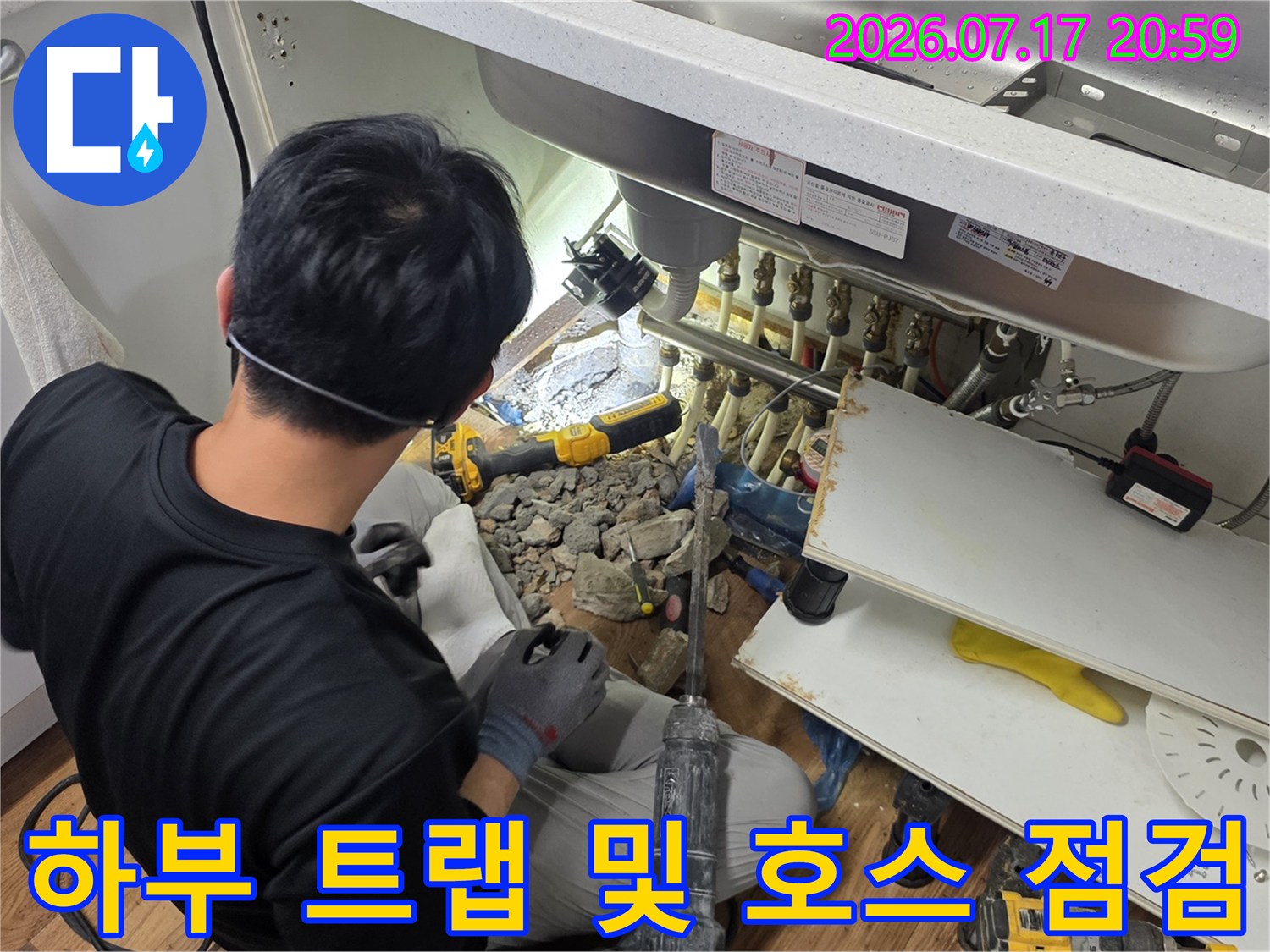 싱크대 아래 설치된 배출용 호스와 연결 부위의 상태를 세밀하게 파악하는 장면