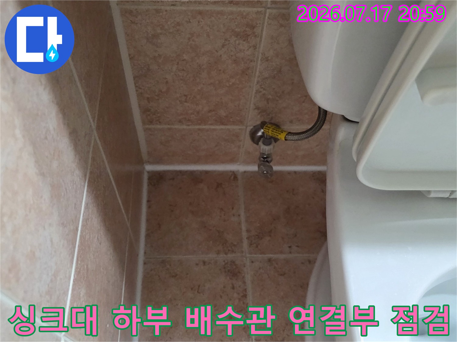 싱크대 아래쪽 노출된 배수관과 밸브 연결 부위 촬영