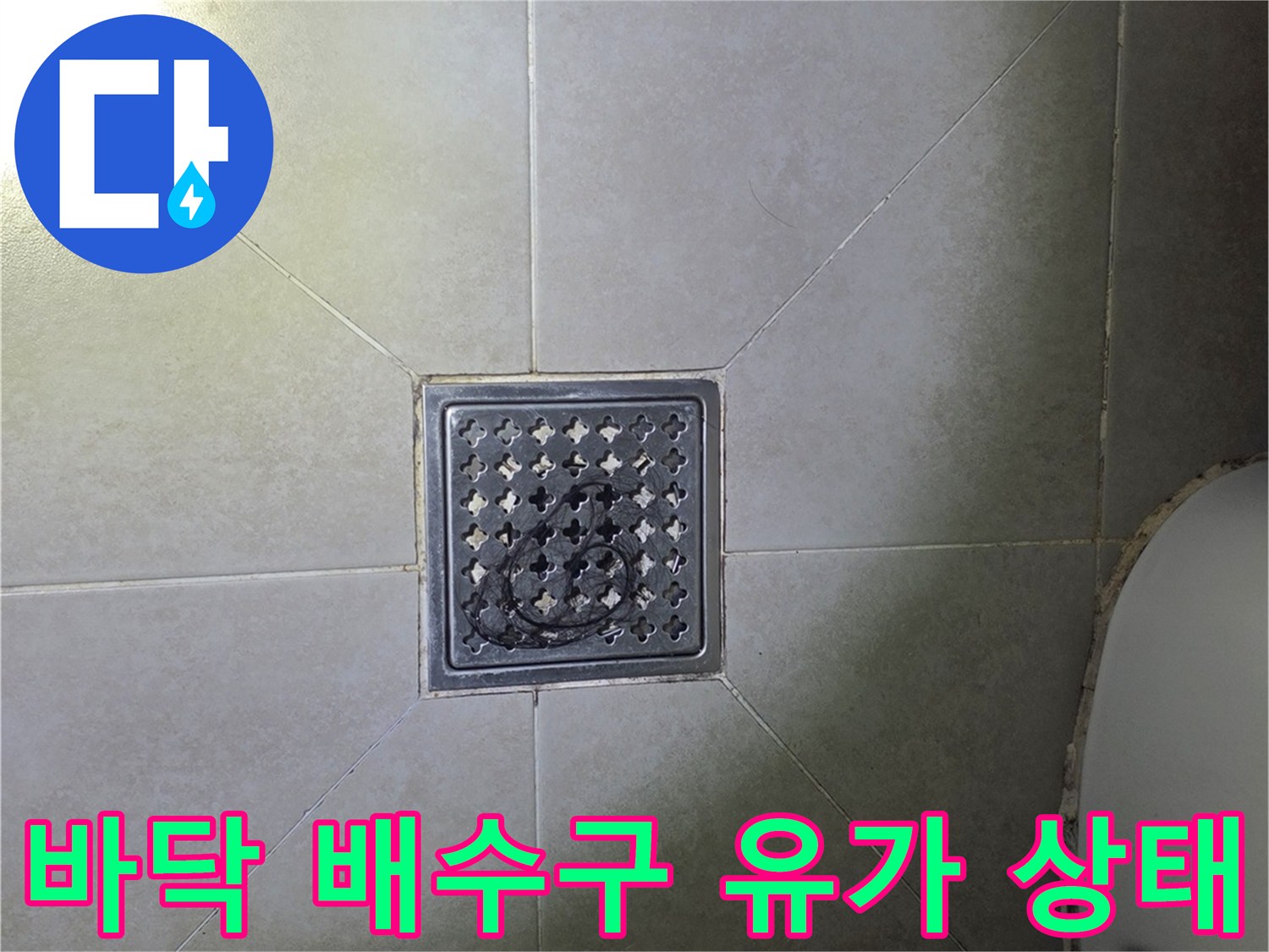 화장실 바닥의 배수구 유가 주변을 촬영한 사진입니다.