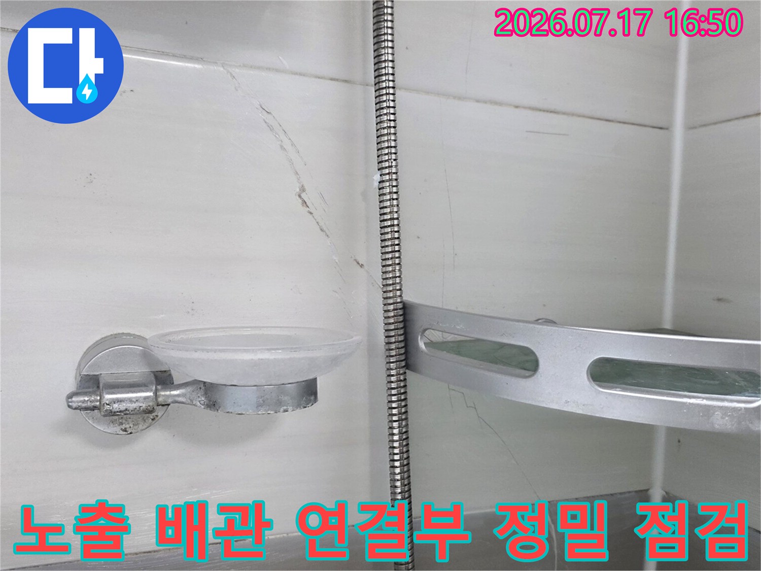 화장실 천장 내부에 위치한 금속제 배관의 이음새와 주변 환경을 조사하는 모습