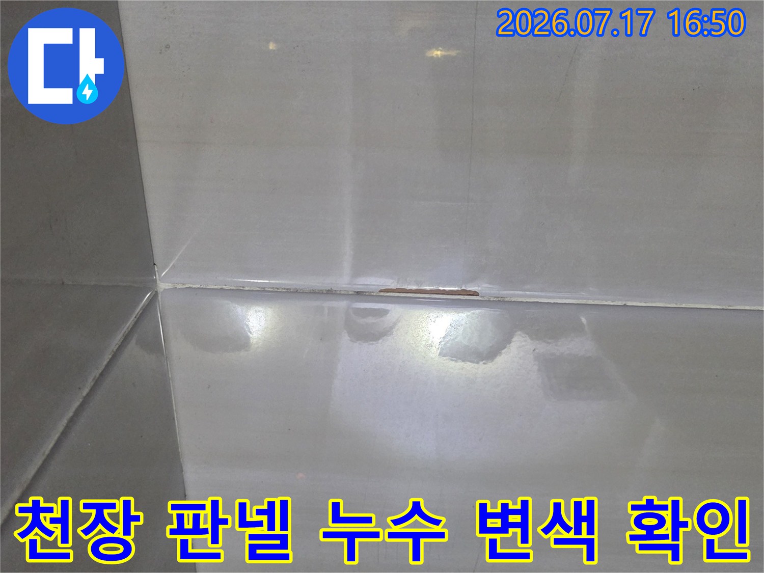 흰색 욕실 천장 판넬의 접합 부분에 나타난 노란색 물 얼룩