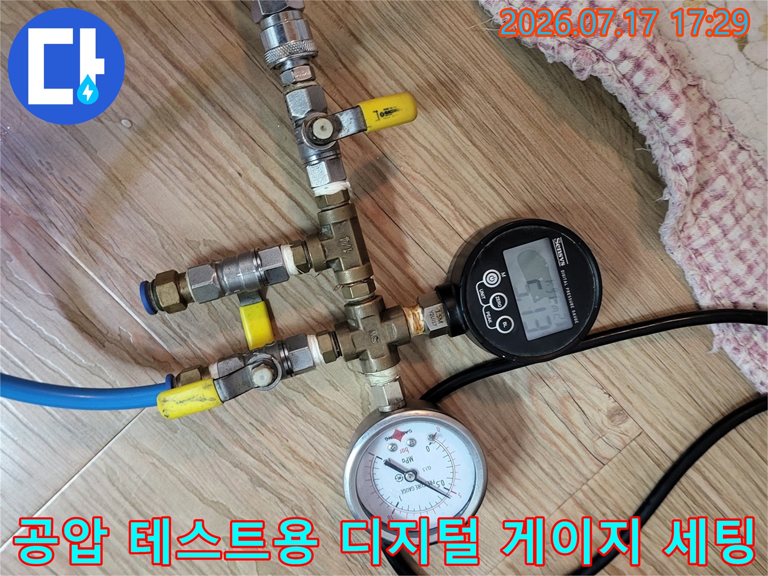 노란색 호스와 파란색 호스가 연결된 누수 진단용 압력 측정 장비 사진