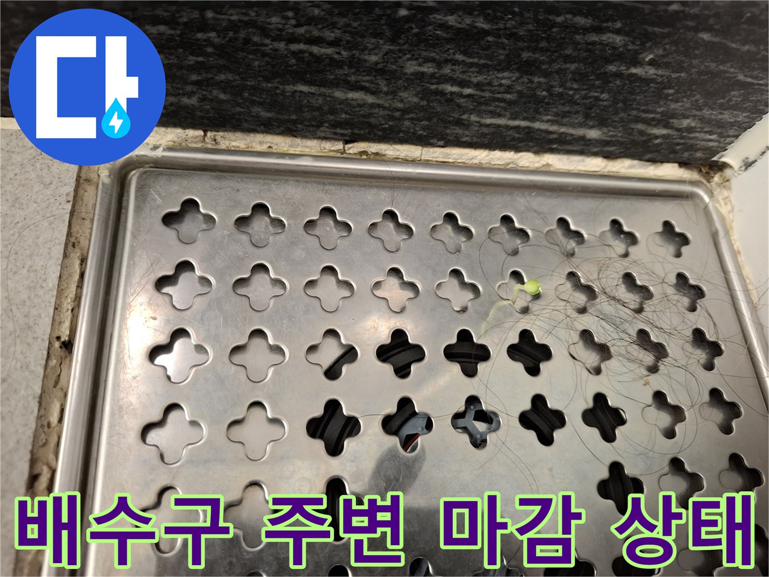 욕실 배수구 유가 덮개와 타일 사이의 경계 부위 사진입니다.