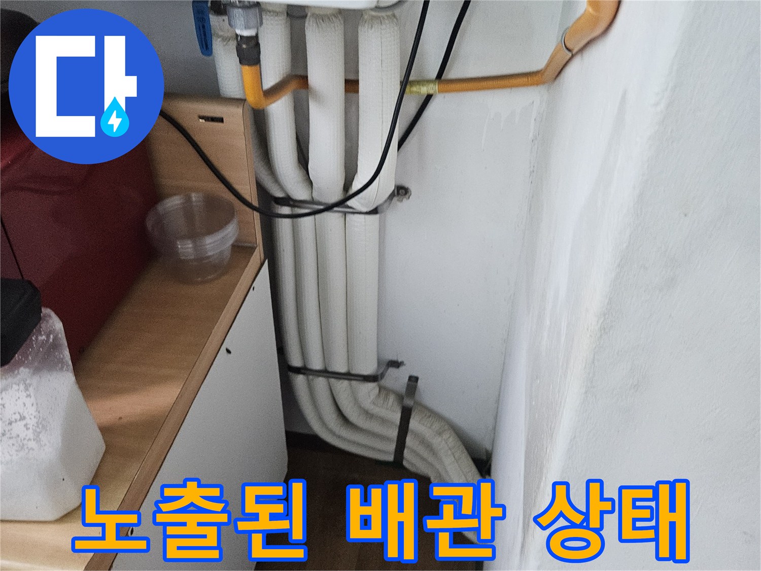 아파트 내부-벽면에 노출된 하얀색 배관과 노란색 관의 모습