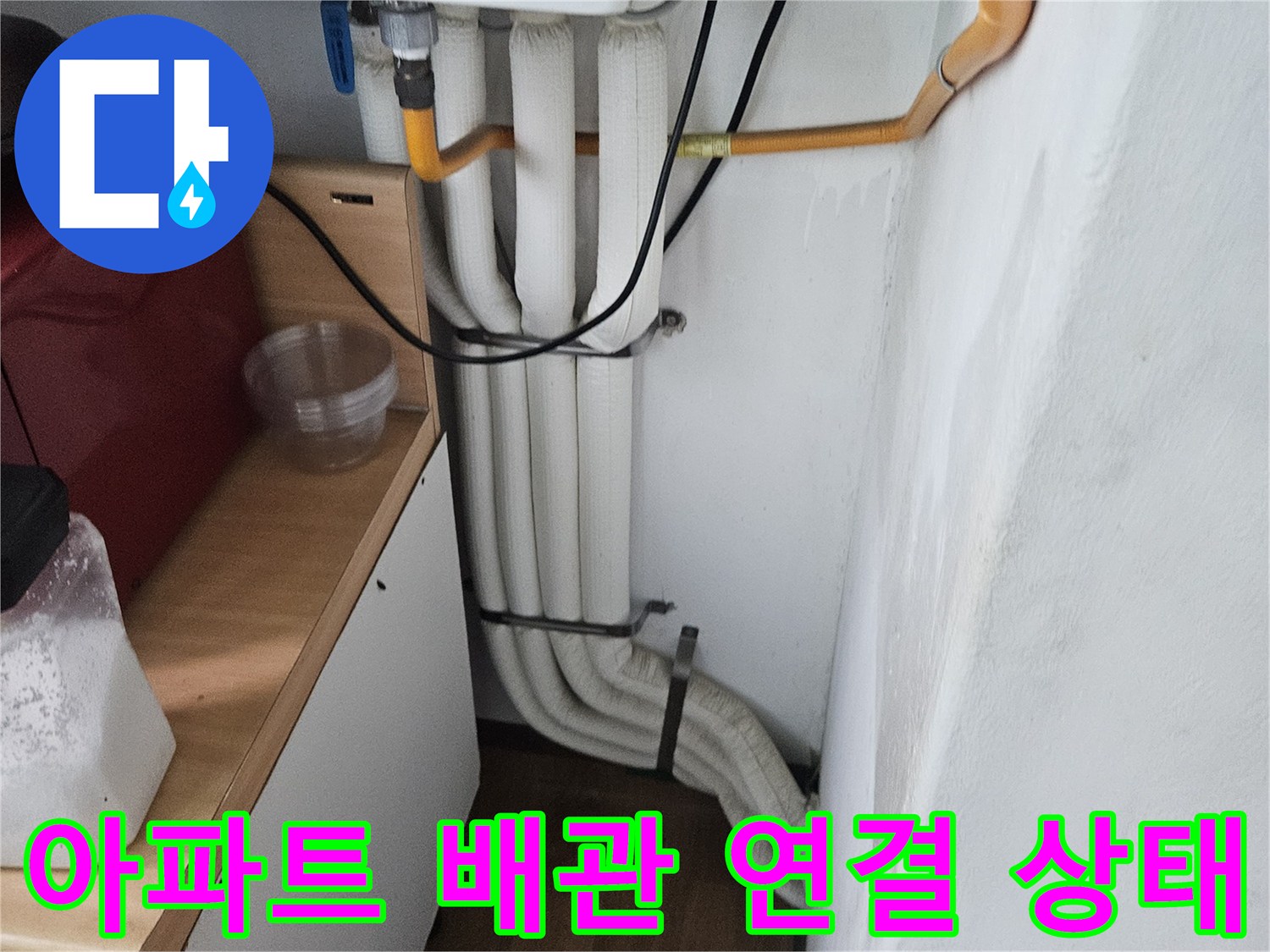 아파트 내부의 노란색과 흰색 배관이 연결된 모습입니다.