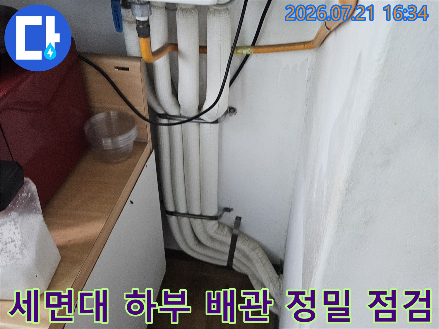 어지럽게 얽힌 세면대 밑 수도 및 배수 시스템 확인