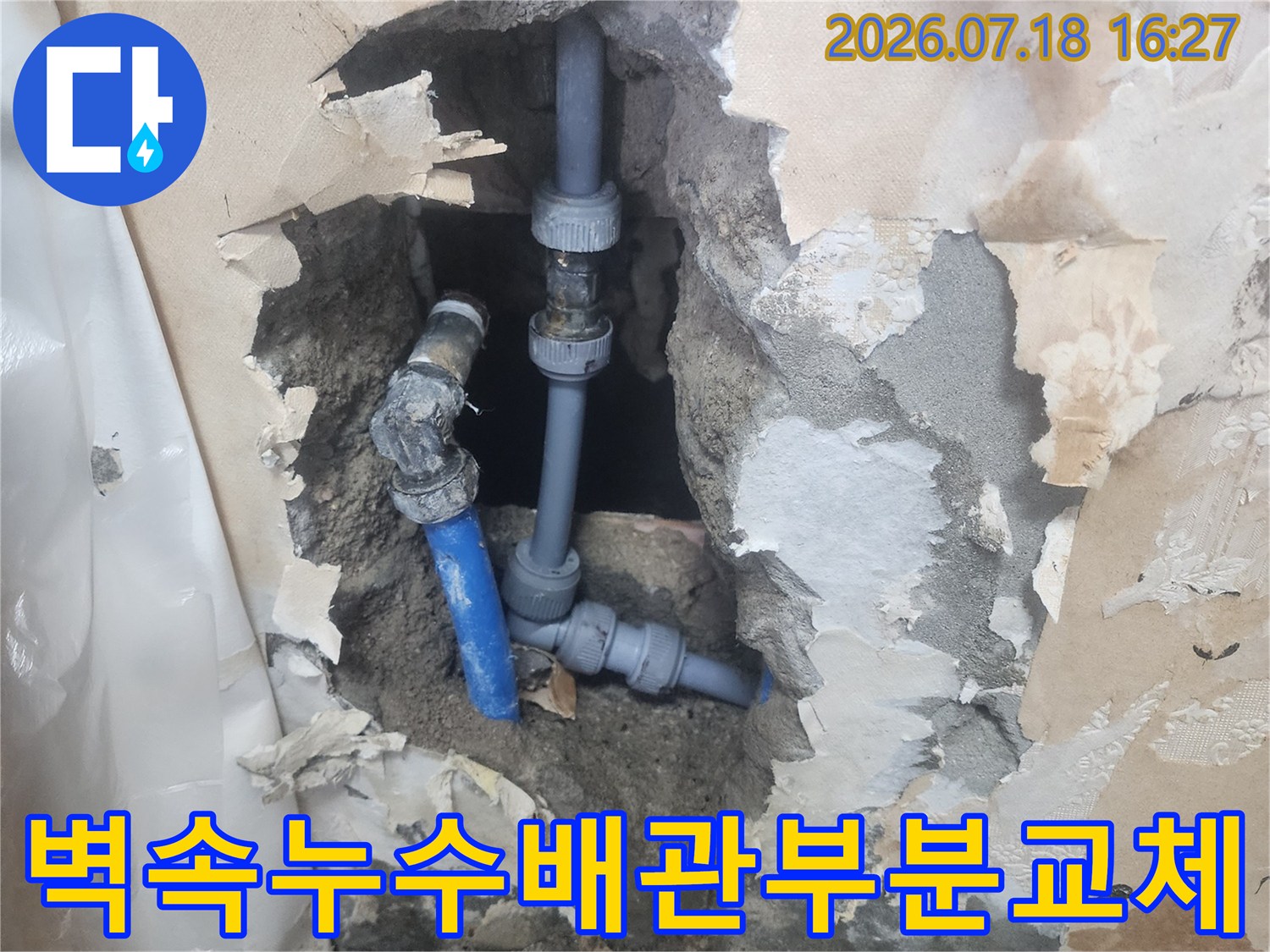 굴착된 시멘트 벽 속에서 수선 완료된 파란색 수도 배관-연결 부위 상세 모습