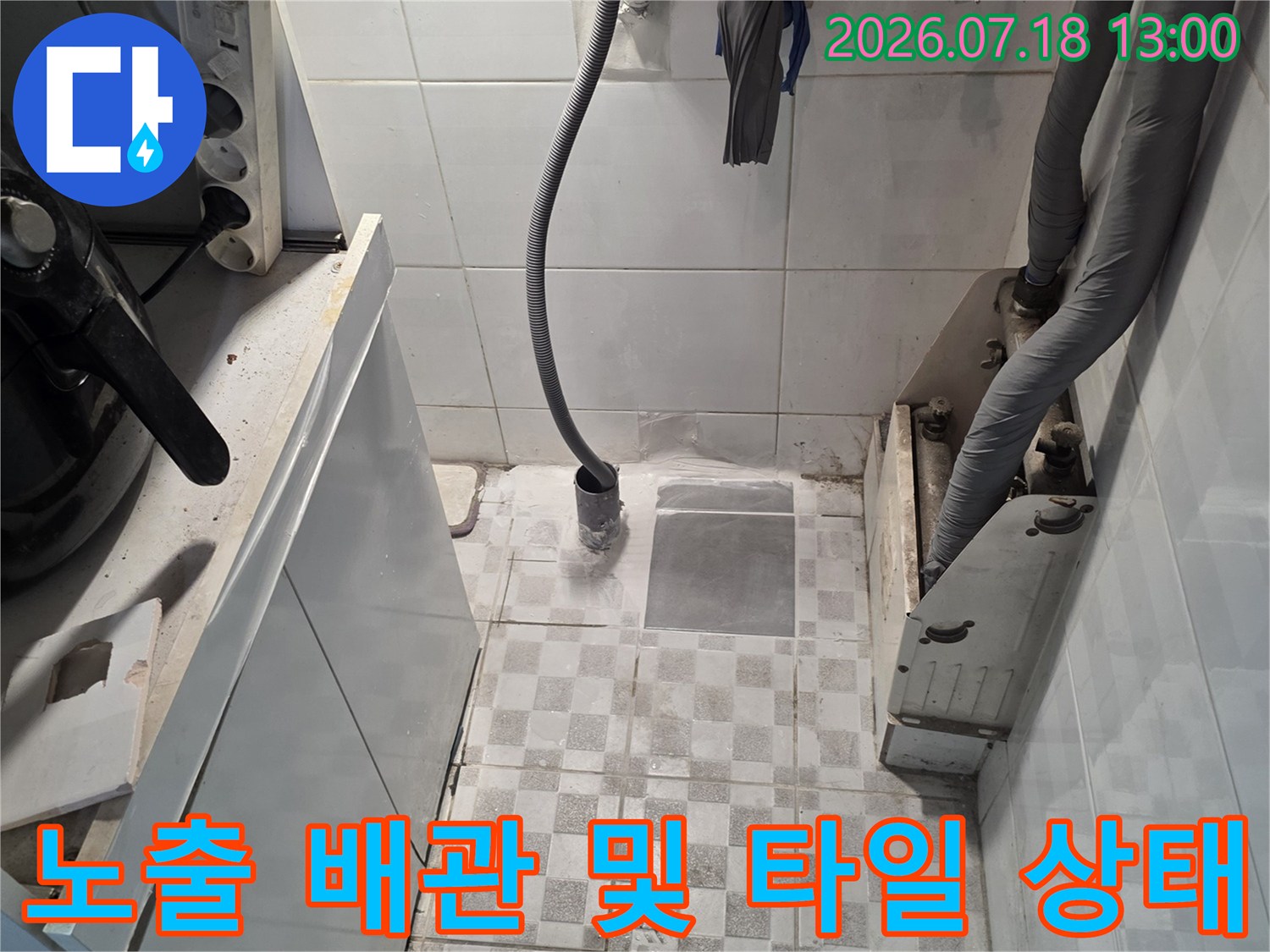 흰색 타일 배경에 회색 단열재 배관-과 노란 호스가 설치된 전경