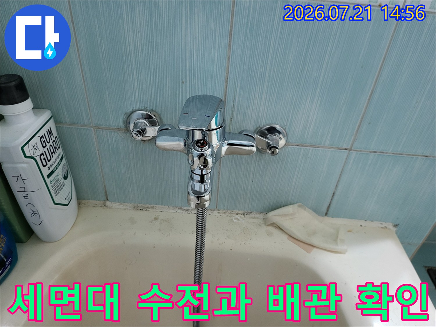세면대 위에 설치된 크롬 소재의 수전과 아래로 연결된 샤워 호스 구조