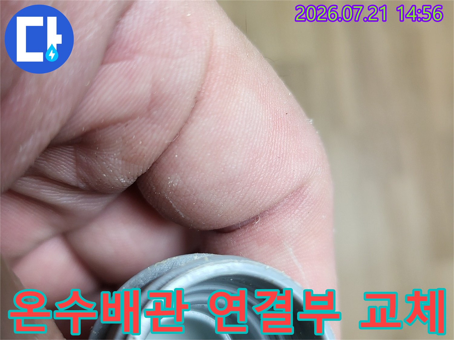 손으로 잡고 있는 온수 배관 연결 부위의 상세 모습