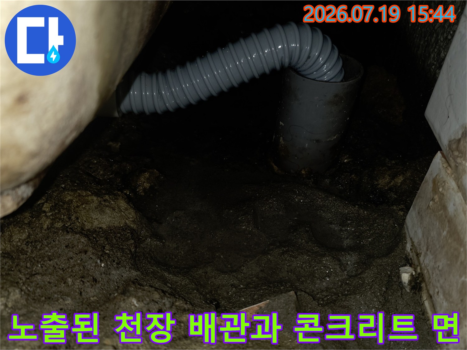 거친-콘크리트-표면-아래로-길게-뻗은-회색-배수-주름관