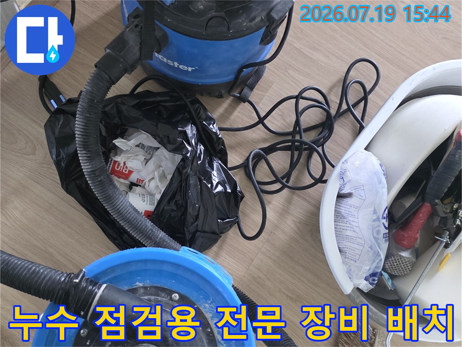 바닥에 놓인 파란색 진공 청소기와 공구함-정밀 누수 탐지 준비 단계