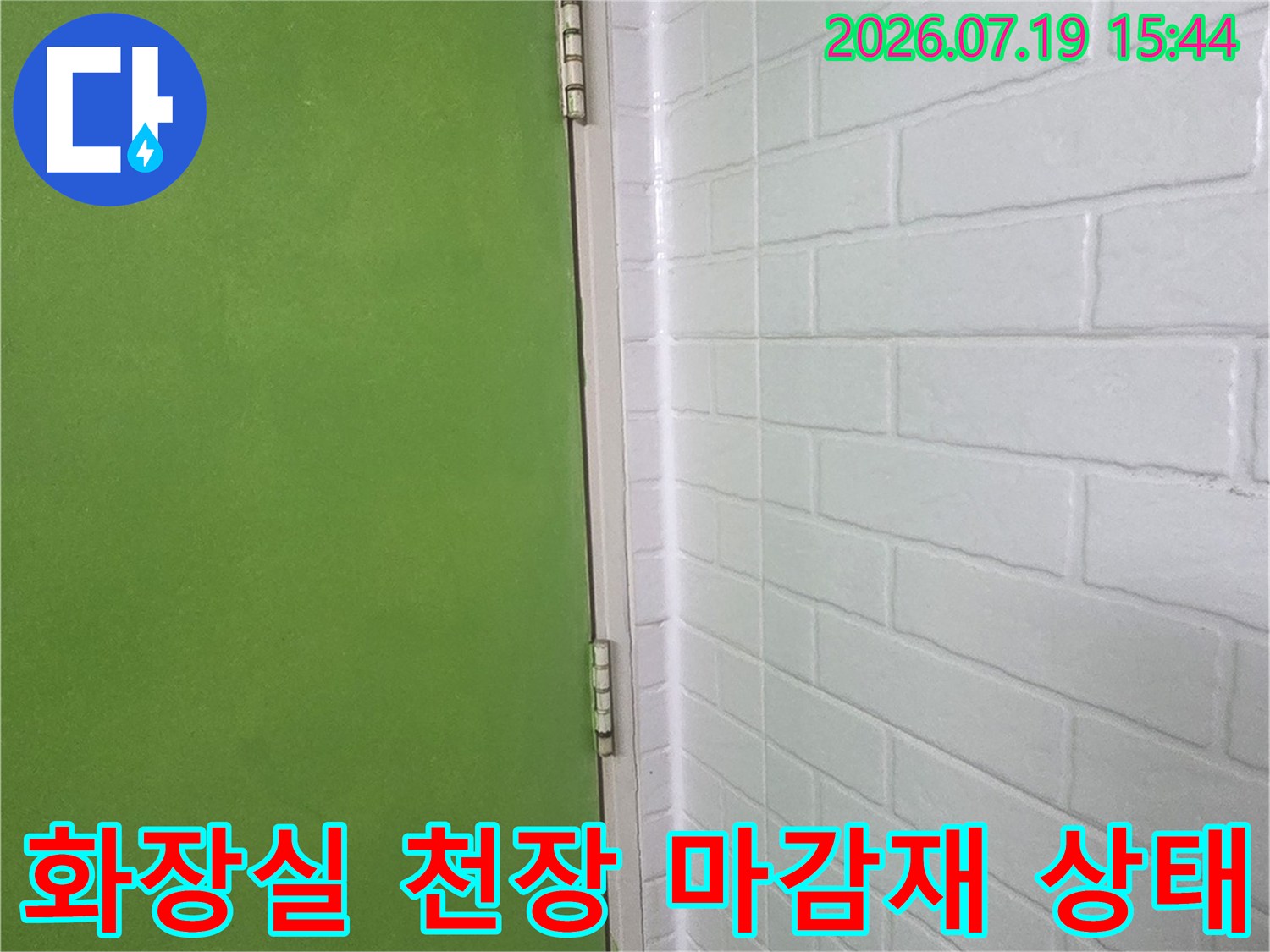 흰색 플라스틱 판넬로 마감된 화장실 천장-벽면 연결 부위 사진